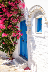 Naklejki  Kolorowe drzwi i kwiaty w białej śródziemnomorskiej ulicy, Amorgo