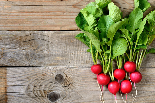 Fresh radishes on wooden table top view