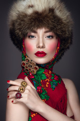 Beautiful woman portrait in russian style with fur hat and scarf