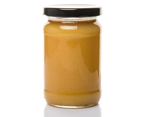 Orange fruit curd in glass jar over white background