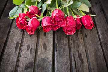 Red roses on wooden background