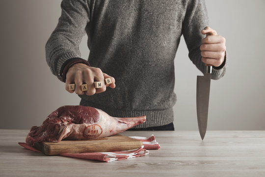 Man holds letters lamb with knife in hand