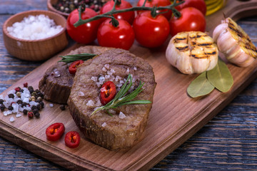  Beef Steak, salt, pepper, garlic, rosemary  on the black board, background.