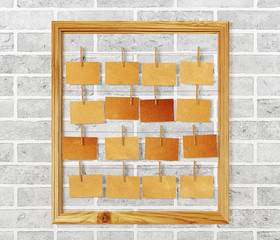 Picture frame and antique note papers hanging on white brick wall background