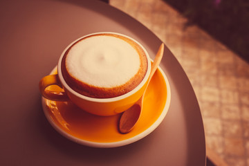 Coffee cup and a wooden spoon on the table circle.
