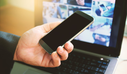 Businessman using smart phone and computer.