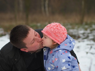 Father and little daughter kissing