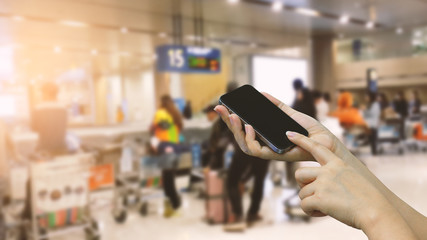 Hands holding smartphone. Airport terminal background
