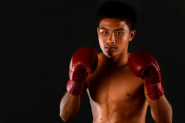 Fototapeta na wymiar Muay Thai boxing male boxer isolated on black backgrounds
