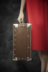 Old suitcase in hands.