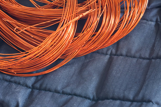 Windings of Copper Wire on a dark background textile. Winding, coil, spool of electrical machines - generator or motor