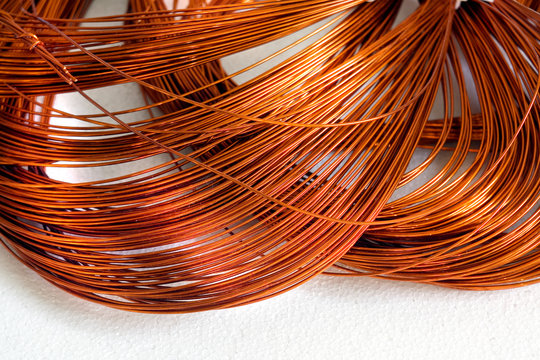 Close-up Skein cooper wire on white background. Copper wire winding, coil, spool section of the electric machine - generator or motor