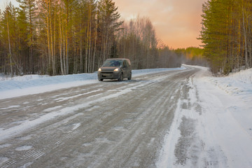 car in the road, winter at dawn