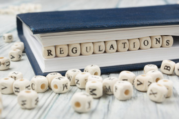 Regulations word written on wood block. Wooden ABC