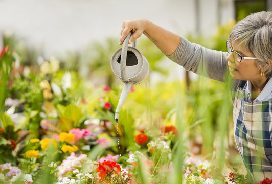 Mature Woman Watering Flowers