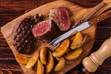 Grilled steak with potato wedges, salsa and spices.