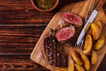 Grilled steak with potato wedges, salsa and spices.