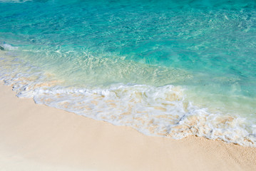 Fototapeta na wymiar Soft wave of the turquoise sea on the sandy beach. Natural summe