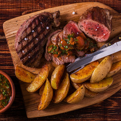 Grilled steak with potato wedges, salsa and spices.