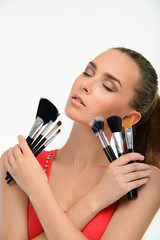 Young woman with a lot of make-up brushes.