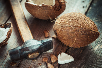 Coconuts and hammer on old wooden table