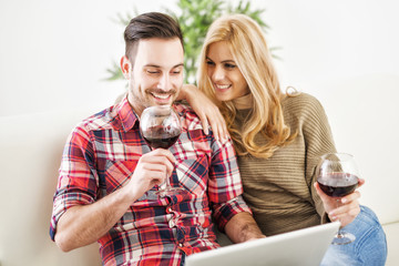 Young couple celebrating with red wine at home
