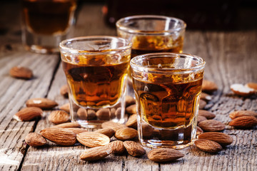 Italian amaretto liqueur with dry almonds on the old wooden back