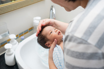 Obraz na płótnie Canvas Asian newborn baby having a bath
