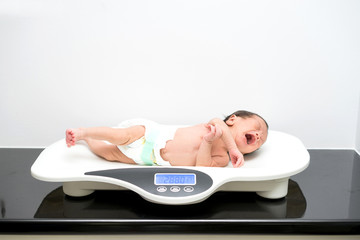 Asian newborn baby laying on the scales © alice_photo