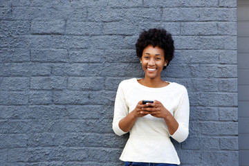 Smiling young african woman with mobile phone