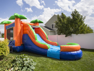 Inflatable bounce house water slide in the backyard
