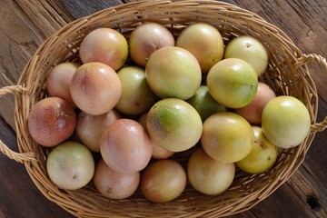 passion Fruits in the bamboo baskets on the wooden background.