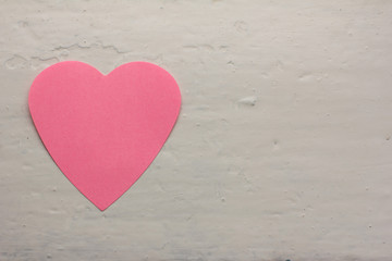 Valentine - paper pink heart against a white painted surface. Copy space. Free space for text, Close-up, top view