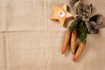 Leinenhintergrund mit Kerze und Fichtenzweig