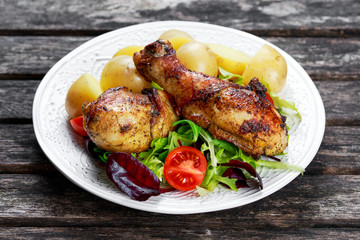 Baked chicken legs with potatoes and vegetables