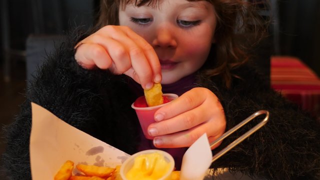 jolie enfant mangeant des frites