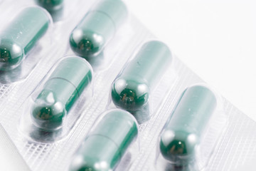 Green capsule medication box on a white background