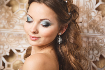 Beautiful young woman in gorgeous blue long dress like Cinderella with perfect make-up and hair style