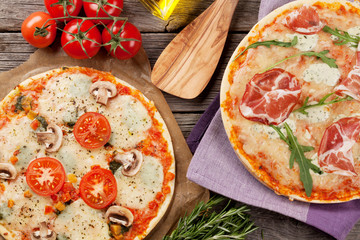 Pizza with prosciutto and mozzarella and with tomatoes and mushr