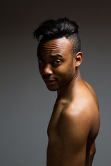 Latin man posing indoor over a grey wall.