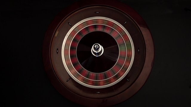 Person spinning roulette on black 