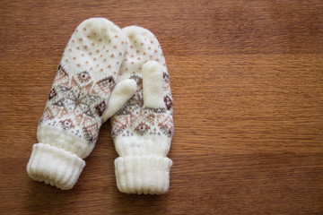 Knitted mittens on wood.