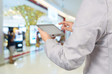 Handsome young man in shopping mall using mobile Tablet PC