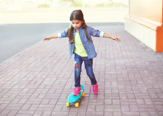 Fashion kid, little girl riding on skateboard in city