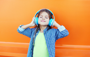 Happy smiling child enjoys listens to music in headphones over c