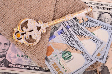 Banknotes hundred dollars, burlap and key.