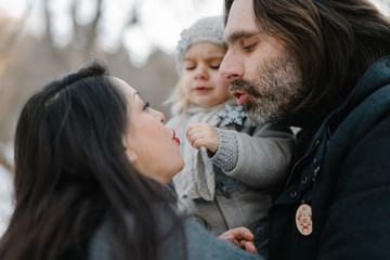 Pregnant mother and father warming their kid's freezing hands