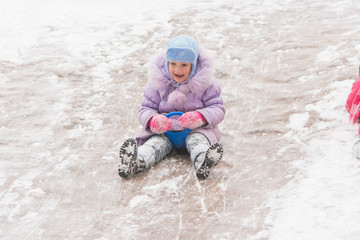 Fototapeta na wymiar Five-year girl in the middle of the ice slides slides