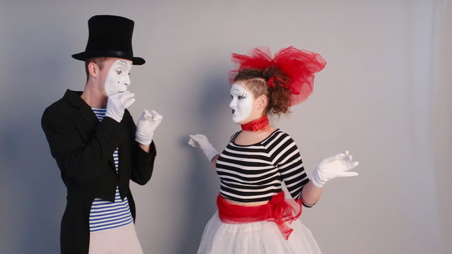 two funny mimes holding invisible heart