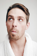 Obraz premium Emotions. Portrait of a Man with a puzzled face in bathrobe